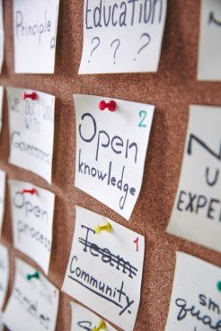 A notice board displays post its about community and open knowledge