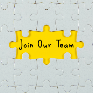 A white jigsaw with some pieces missing in the middle on a yellow background with 'Join our team' written in the gap